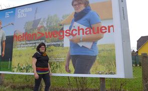 Christa Außerwöger auf und vor einem jener Plakate, die derzeit für die Haussammlung werben.