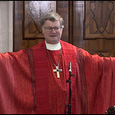 Bischof Scheuer verdeutlicht, wie wir mit unserem Körper ein Kreuz bilden können, wenn wir die Arme ausbreiten.